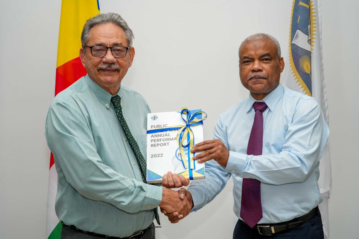 Hon. Roger Mancienne receiving the PEMC Report