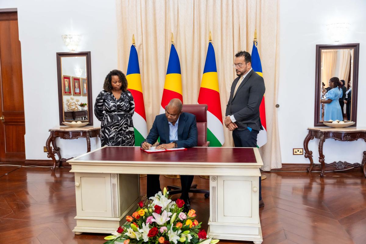 President Dr. Patrick Herminie ascenting the bill